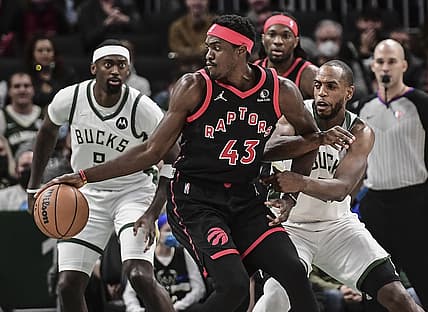Jan 15, 2022; Milwaukee, Wisconsin, USA; Toronto Raptors forward Pascal Siakam (43) is guarded by Milwaukee Bucks center Bobby Portis (9) and forward Khris Middleton (22) in the first quarter at Fiserv Forum. Mandatory Credit: Benny Sieu-USA TODAY Sports