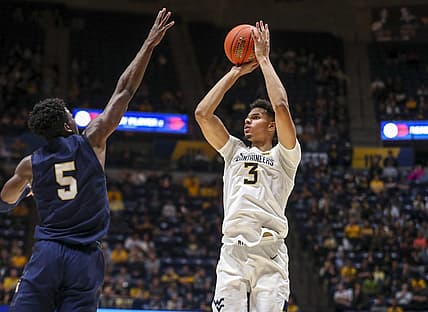 Dec 7, 2022; Morgantown, West Virginia, USA; West Virginia Mountaineers forward Tre Mitchell (3) shoots a three pointer over Navy Midshipmen forward Tyler Nelson (5) during the second half at WVU Coliseum. Mandatory Credit: Ben Queen-USA TODAY Sports