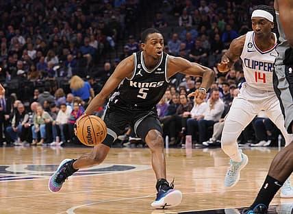 Mar 3, 2023; Sacramento, California, USA; Sacramento Kings point guard De'Aaron Fox (5) drives in against Los Angeles Clippers shooting guard Terance Mann (14) during the second quarter at Golden 1 Center. Mandatory Credit: Kelley L Cox-USA TODAY Sports