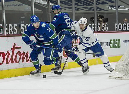 Apr 18, 2021; Vancouver, British Columbia, CAN; Vancouver Canucks forward Jimmy Vesey (24) checks Toronto Maple Leafs forward John Tavares (91) in the first period at Rogers Arena. Mandatory Credit: Bob Frid-USA TODAY Sports