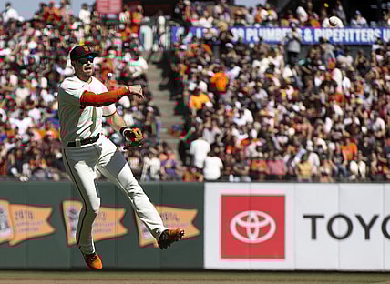 Oct 3, 2021; San Francisco, California, USA; San Francisco Giants third baseman Evan Longoria (10) leaves his feet to throw out San Diego Padres shortstop Fernando Tatis Jr. at first base during the fourth inning at Oracle Park. Mandatory Credit: D. Ross Cameron-USA TODAY Sports