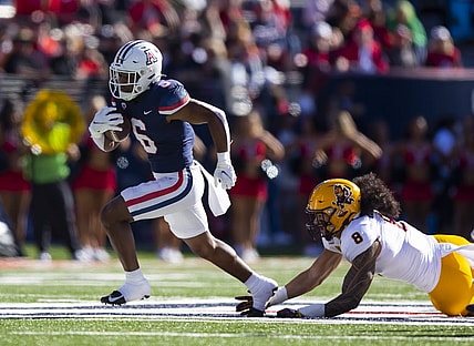 Nov 25, 2022; Tucson, Arizona, USA; Arizona Wildcats running back Michael Wiley (6) runs for a touchdown against diving Arizona State Sun Devils linebacker Merlin Robertson (8) in the first half of the Territorial Cup at Arizona Stadium. Mandatory Credit: Mark J. Rebilas-USA TODAY Sports