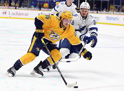 Apr 10, 2021; Nashville, Tennessee, USA; Nashville Predators center Rem Pitlick (16) skates with the puck past pressure from Tampa Bay Lightning defenseman Mikhail Sergachev (98) during the first period at Bridgestone Arena. Mandatory Credit: Christopher Hanewinckel-USA TODAY Sports