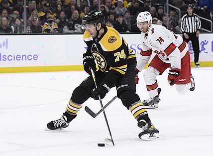Feb 10, 2022; Boston, Massachusetts, USA; Boston Bruins left wing Jake DeBrusk (74) skates in on goal while Carolina Hurricanes defenseman Jaccob Slavin (74) pursues during the third period at TD Garden. Mandatory Credit: Bob DeChiara-USA TODAY Sports