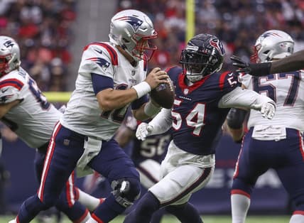 Oct 10, 2021; Houston, Texas, USA; New England Patriots quarterback Mac Jones (10) scrambles with the ball as Houston Texans defensive end Jake Martin (54) defends during the second quarter at NRG Stadium. Mandatory Credit: Troy Taormina-USA TODAY Sports