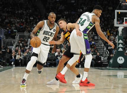 Mar 9, 2022; Milwaukee, Wisconsin, USA;  Milwaukee Bucks forward Khris Middleton (22) drives past the pick of Milwaukee Bucks forward Giannis Antetokounmpo (34) as Atlanta Hawks guard Bogdan Bogdanovic (13) attempts to work his way through the pick in the first quarter at Fiserv Forum. Mandatory Credit: Michael McLoone-USA TODAY Sports