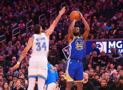 Feb 6, 2023; San Francisco, California, USA; Golden State Warriors small forward Andrew Wiggins (22) scores a three point basket against Oklahoma City Thunder shooting guard Kenrich Williams (34) during the second quarter at Chase Center. Mandatory Credit: Kelley L Cox-USA TODAY Sports