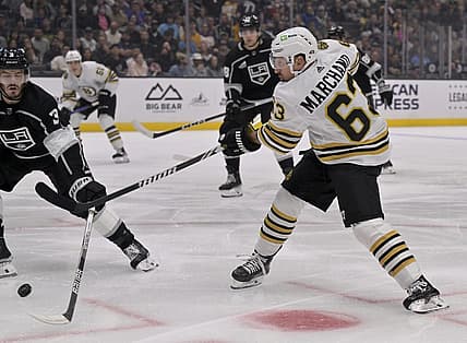 Oct 21, 2023; Los Angeles, California, USA; Boston Bruins left wing Brad Marchand (63) shoots against Los Angeles Kings defenseman Matt Roy (3) during the first period at Crypto.com Arena. Mandatory Credit: Alex Gallardo-USA TODAY Sports