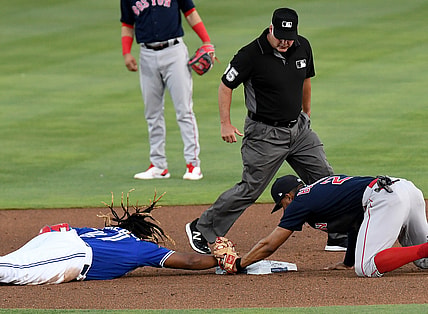 May 19, 2021; Dunedin, Florida, CAN; Toronto Blue Jays infielder Vladimir Guerrero Jr. (27) dives back to second base as Boston Red Sox infielder Xander Bogaerts (2) attempts a tag in the first inning  at TD Ballpark. Mandatory Credit: Jonathan Dyer-USA TODAY Sports