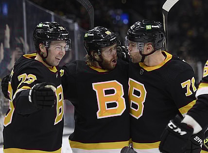 Jan 4, 2022; Boston, Massachusetts, USA;  Boston Bruins right wing David Pastrnak (88) reacts with defenseman Charlie McAvoy (73) and left wing Taylor Hall (71) after scoring a goal during the third period against the New Jersey Devils at TD Garden. Mandatory Credit: Bob DeChiara-USA TODAY Sports