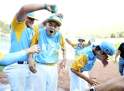 Aug 28, 2022; Williamsport, PA, USA; West Region shortstop Kekoa Payanal (15) and outfielder Kama Angell (14) get doused with gatorade by first baseman Esaiah Wong (20) and third baseman Daly Watson (12) after beating the Caribbean Region 13-3 at Lamade Stadium. Mandatory Credit: Evan Habeeb-USA TODAY Sports