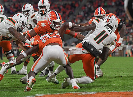 Nov 19, 2022; Clemson, South Carolina, USA; Clemson Tigers defensive end Justin Mascoll (7) pushes over Miami Hurricanes quarterback Jacurri Brown (11) for a safety during the third quarter at Memorial Stadium. Mandatory Credit: Ken Ruinard-USA TODAY Sports