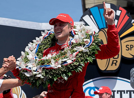May 29, 2022; Indianapolis, IN, USA;  Chip Ganassi Racing driver Marcus Ericsson (8) celebrates on the podium with the milk after winning the 106th running of the Indianapolis 500 at Indianapolis Motor Speedway. Mandatory Credit: Mykal McEldowney-USA TODAY Sports