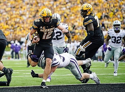 Sep 16, 2023; Columbia, Missouri, USA; Missouri Tigers quarterback Brady Cook (12) scores a touchdown against Kansas State Wildcats defensive end Brendan Mott (38) during the first half at Faurot Field at Memorial Stadium. Mandatory Credit: Jay Biggerstaff-USA TODAY Sports