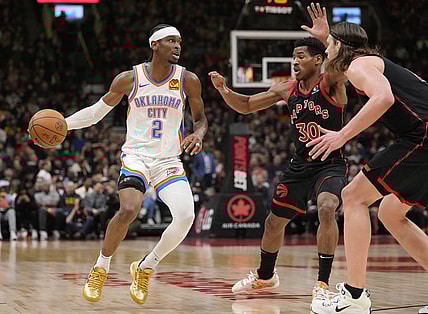 Mar 22, 2024; Toronto, Ontario, CAN; Oklahoma City Thunder guard Shai Gilgeous-Alexander (2) looks to make a play against Toronto Raptors guard Ochai Agbaji (30) and  forward Kelly Olynyk (41) during the first half at Scotiabank Arena. Mandatory Credit: John E. Sokolowski-USA TODAY Sports