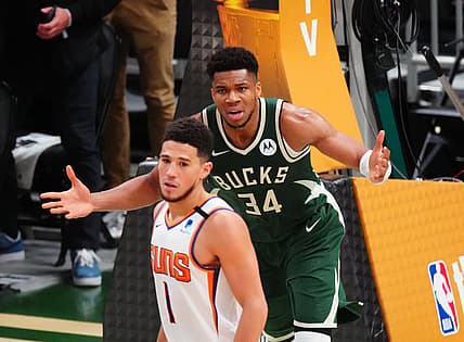 Jul 11, 2021; Milwaukee, Wisconsin, USA; Milwaukee Bucks forward Giannis Antetokounmpo (34) reacts alongside Phoenix Suns guard Devin Booker (1) during game three of the 2021 NBA Finals at Fiserv Forum. Mandatory Credit: Mark J. Rebilas-USA TODAY Sports