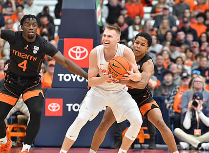 Mar 5, 2022; Syracuse, New York, USA; Syracuse Orange guard Buddy Boeheim (35) is defended by Miami (Fl) Hurricanes guard Charlie Moore (right) and guard Bensley Joseph (4) in the first half at the Carrier Dome. Mandatory Credit: Mark Konezny-USA TODAY Sports