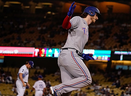 Jun 12, 2021; Los Angeles, California, USA; Texas Rangers catcher Jonah Heim (right) rounds third base after hitting a two run home run against Los Angeles Dodgers starting pitcher Trevor Bauer (background) in the fourth inning at Dodger Stadium. Mandatory Credit: Robert Hanashiro-USA TODAY Sports