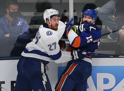 Jun 19, 2021; Uniondale, New York, USA; New York Islanders right wing Cal Clutterbuck (15) and Tampa Bay Lightning defenseman Ryan McDonagh (27) come together at the boards during the third period of game four of the 2021 Stanley Cup Semifinals at Nassau Veterans Memorial Coliseum. Mandatory Credit: Andy Marlin-USA TODAY Sports