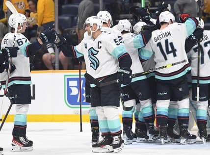 Oct 14, 2021; Nashville, Tennessee, USA; Seattle Kraken Seattle Kraken defenseman Mark Giordano (5) celebrates with teammates after the first win in franchise history following a win against the Nashville Predators at Bridgestone Arena. Mandatory Credit: Christopher Hanewinckel-USA TODAY Sports