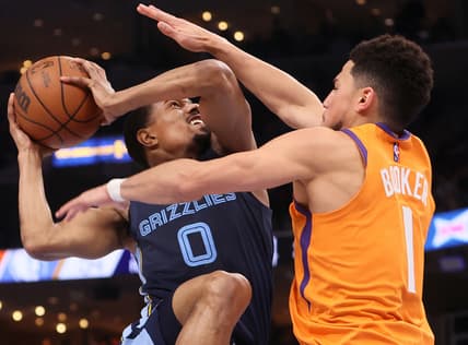 Apr 1, 2022; Memphis, Tennessee, USA; Memphis Grizzlies guard De'Anthony Melton (0) shoots the ball over Phoenix Suns guard Devin Booker (1) at FedExForum. Mandatory Credit: Joe Rondone-USA TODAY Sports