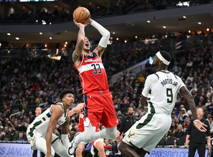 Jan 1, 2023; Milwaukee, Wisconsin, USA;  Washington Wizards forward Kyle Kuzma (33) shoots the ball over Milwaukee Bucks forward Bobby Portis (9) in the first half at Fiserv Forum. Mandatory Credit: Michael McLoone-USA TODAY Sports