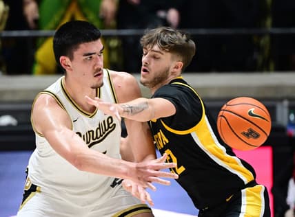 Dec 4, 2023; West Lafayette, Indiana, USA; Purdue Boilermakers center Zach Edey (15) passes the ball past Iowa Hawkeyes forward Owen Freeman (32) during the first half at Mackey Arena. Mandatory Credit: Marc Lebryk-USA TODAY Sports