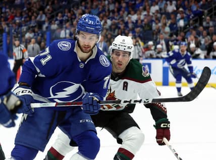 Jan 25, 2024; Tampa, Florida, USA; Tampa Bay Lightning center Anthony Cirelli (71) and Arizona Coyotes center Nick Schmaltz (8) look after the puck during the first period at Amalie Arena. Mandatory Credit: Kim Klement Neitzel-USA TODAY Sports