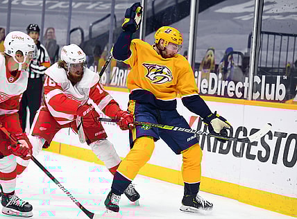 Feb 13, 2021; Nashville, Tennessee, USA; Nashville Predators center Yakov Trenin (13) plays the puck out of the air against Detroit Red Wings defenseman Marc Staal (18) during the first period at Bridgestone Arena. Mandatory Credit: Christopher Hanewinckel-USA TODAY Sports