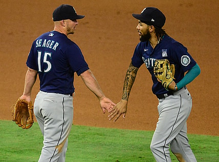 Jun 3, 2021; Anaheim, California, USA; Seattle Mariners third baseman Kyle Seager (15) and shortstop J.P. Crawford (3) celebrate the 6-2 victory against the Los Angeles Angels at Angel Stadium. Mandatory Credit: Gary A. Vasquez-USA TODAY Sports