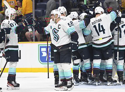 Oct 14, 2021; Nashville, Tennessee, USA; Seattle Kraken Seattle Kraken defenseman Mark Giordano (5) celebrates with teammates after the first win in franchise history following a win against the Nashville Predators at Bridgestone Arena. Mandatory Credit: Christopher Hanewinckel-USA TODAY Sports