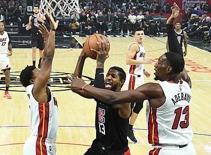 Nov 11, 2021; Los Angeles, California, USA;  Los Angeles Clippers guard Paul George (13) goes up for a basket as he is defended by Miami Heat guard Kyle Lowry (7) and center Bam Adebayo (13) in the first half at Staples Center. Mandatory Credit: Jayne Kamin-Oncea-USA TODAY Sports