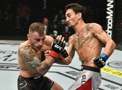 July 12, 2020; Abu Dhabi, UAE;  Max Holloway punches Alexander Volkanovski of Australia in their UFC featherweight championship fight during the UFC 251 event at Flash Forum on UFC Fight Island on July 12, 2020 on Yas Island, Abu Dhabi, United Arab Emirates.  Mandatory Credit: Jeff Bottari/Zuffa LLC via USA TODAY Sports