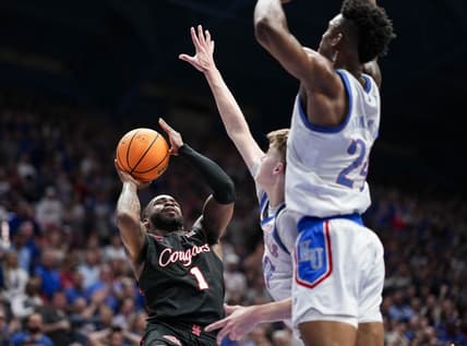 Feb 3, 2024; Lawrence, Kansas, USA; Houston Cougars guard Jamal Shead (1) shoots against Kansas Jayhawks guard Johnny Furphy (10) and forward K.J. Adams Jr. (24) during the first half at Allen Fieldhouse. Mandatory Credit: Jay Biggerstaff-USA TODAY Sports