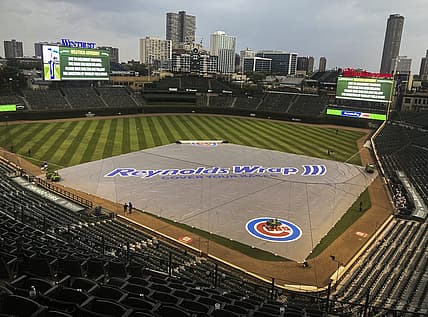 Jul 24, 2021; Chicago, Illinois, USA; Chicago Cubs grounds crew members place the tarp during a rain delay in the ninth inning against the Arizona Diamondbacks at Wrigley Field. Mandatory Credit: Matt Marton-USA TODAY Sports