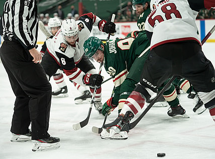Apr 14, 2021; Saint Paul, Minnesota, USA;  Arizona Coyotes center Nick Schmaltz (8) and Minnesota Wild center Marcus Johansson (90) face off as Arizona Coyotes left wing Michael Bunting (58) and Minnesota Wild left wing Kevin Fiala (22) and linesman Devin Berg (87) watch at Xcel Energy Center. Mandatory Credit: Matt Blewett-USA TODAY Sports