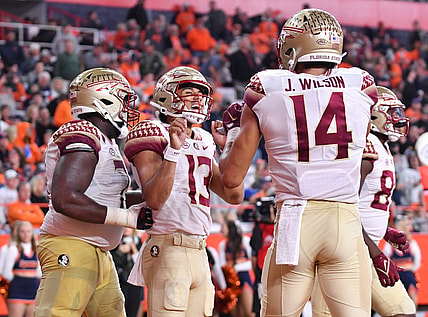 Nov 12, 2022; Syracuse, New York, USA; Florida State Seminoles quarterback Jordan Travis (13) celebrates catching a touchdown pass with wide receiver Johnny Wilson (14) in the third quarter against the Syracuse Orange at JMA Wireless Dome. Mandatory Credit: Mark Konezny-USA TODAY Sports