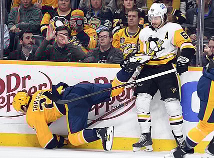 Feb 28, 2023; Nashville, Tennessee, USA; Nashville Predators center Philip Tomasino (26) is hit by Pittsburgh Penguins defenseman Kris Letang (58) during the third period at Bridgestone Arena. Mandatory Credit: Christopher Hanewinckel-USA TODAY Sports