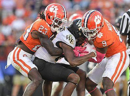 Oct 7, 2023; Clemson, South Carolina, USA; Clemson Tigers cornerback Toriano Pride Jr. (23) and safety R.J. Mickens (9) tackle Wake Forest Demon Deacons defensive back Justin Simpkins (80) during the fourth quarter at Memorial Stadium. Mandatory Credit: Ken Ruinard-USA TODAY Sports