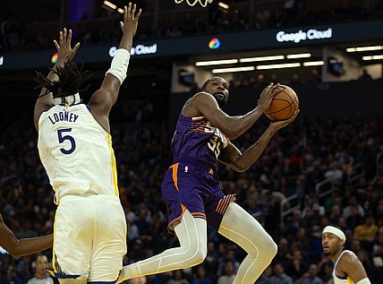 Oct 24, 2023; San Francisco, California, USA; Phoenix Suns forward Kevin Durant (35) shoots around Golden State Warriors forward Kevon Looney (5) during the second quarter at Chase Center. Mandatory Credit: D. Ross Cameron-USA TODAY Sports