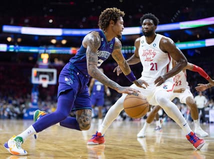 Dec 11, 2022; Philadelphia, Pennsylvania, USA; Charlotte Hornets guard Kelly Oubre Jr. (12) drives against Philadelphia 76ers center Joel Embiid (21) during the first quarter at Wells Fargo Center. Mandatory Credit: Bill Streicher-USA TODAY Sports