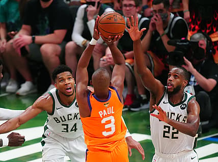 Jul 14, 2021; Milwaukee, Wisconsin, USA; Phoenix Suns guard Chris Paul (3) shoots the ball against Milwaukee Bucks forward Giannis Antetokounmpo (34) and Khris Middleton (22) during game four of the 2021 NBA Finals at Fiserv Forum. Mandatory Credit: Mark J. Rebilas-USA TODAY Sports