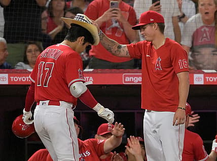 Aug 29, 2022; Anaheim, California, USA;  Los Angeles Angels designated hitter Shohei Ohtani (17) has the home run cowboy hat placed on his head by Mickey Moniak (16) after hitting a two-run home run in the fifth inning off New York Yankees starting pitcher Frankie Montas (not pictured) at Angel Stadium. Mandatory Credit: Jayne Kamin-Oncea-USA TODAY Sports