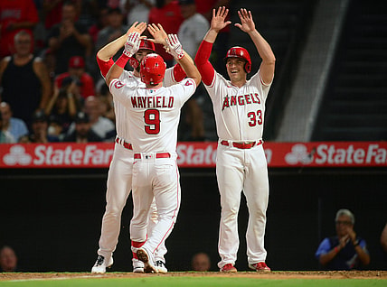 Aug 30, 2021; Anaheim, California, USA; Los Angeles Angels shortstop Jack Mayfield (9) is greeted by first baseman Jared Walsh (20) and catcher Max Stassi (33) after hitting a grand slam home run against the New York Yankees during the fourth inning at Angel Stadium. Mandatory Credit: Gary A. Vasquez-USA TODAY Sports