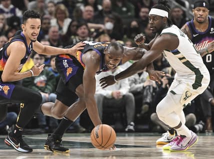 Mar 6, 2022; Milwaukee, Wisconsin, USA; Phoenix Suns center Bismack Biyombo (18) and guard Landry Shamet (14) reach for a loose ball against Milwaukee Bucks guard Jrue Holiday (21)  in the second quarter at Fiserv Forum. Mandatory Credit: Benny Sieu-USA TODAY Sports