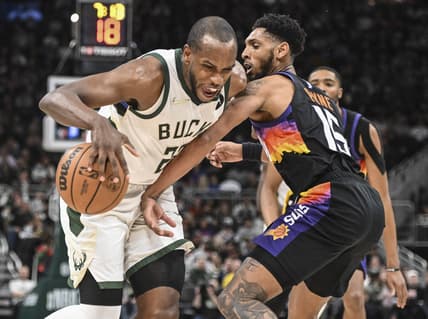 Mar 6, 2022; Milwaukee, Wisconsin, USA; Milwaukee Bucks forward Khris Middleton (22) drives for the basket against Phoenix Suns guard Cameron Payne (15) in the fourth quarter at Fiserv Forum. Mandatory Credit: Benny Sieu-USA TODAY Sports