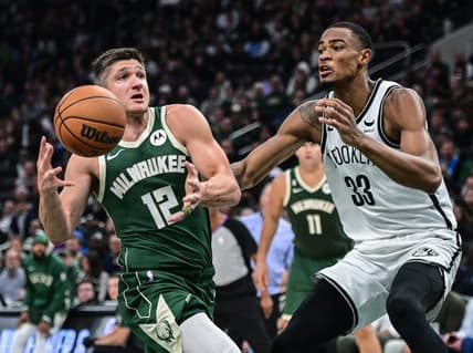 Oct 26, 2022; Milwaukee, Wisconsin, USA; Milwaukee Bucks guard Grayson Allen (12) drives to the basket against Brooklyn Nets center Nicolas Claxton (33) in the second quarter at Fiserv Forum. Mandatory Credit: Benny Sieu-USA TODAY Sports