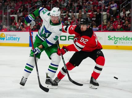 Feb 10, 2024; Raleigh, North Carolina, USA; Carolina Hurricanes right wing Andrei Svechnikov (37) and New Jersey Devils defenseman Santeri Hatakka (82) watch the shot during the second period at PNC Arena. Mandatory Credit: James Guillory-USA TODAY Sports