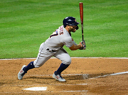 Apr 5, 2021; Anaheim, California, USA; Houston Astros second baseman Jose Altuve (27) hits an RBI single against the Los Angeles Angels during the fourth inning  at Angel Stadium. Mandatory Credit: Gary A. Vasquez-USA TODAY Sports