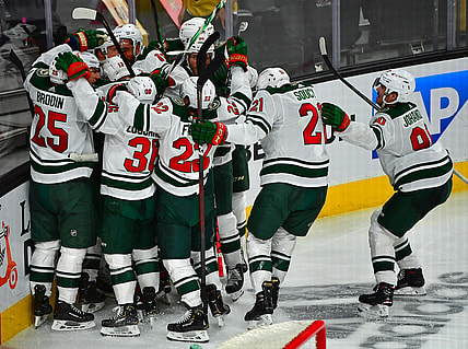 May 16, 2021; Las Vegas, Nevada, USA; Minnesota Wild players celebrate after Minnesota Wild center Joel Eriksson Ek (14) scored an overtime goal to defeat the Vegas Golden Knights 1-0 in game one of the first round of the 2021 Stanley Cup Playoffs at T-Mobile Arena. Mandatory Credit: Stephen R. Sylvanie-USA TODAY Sports